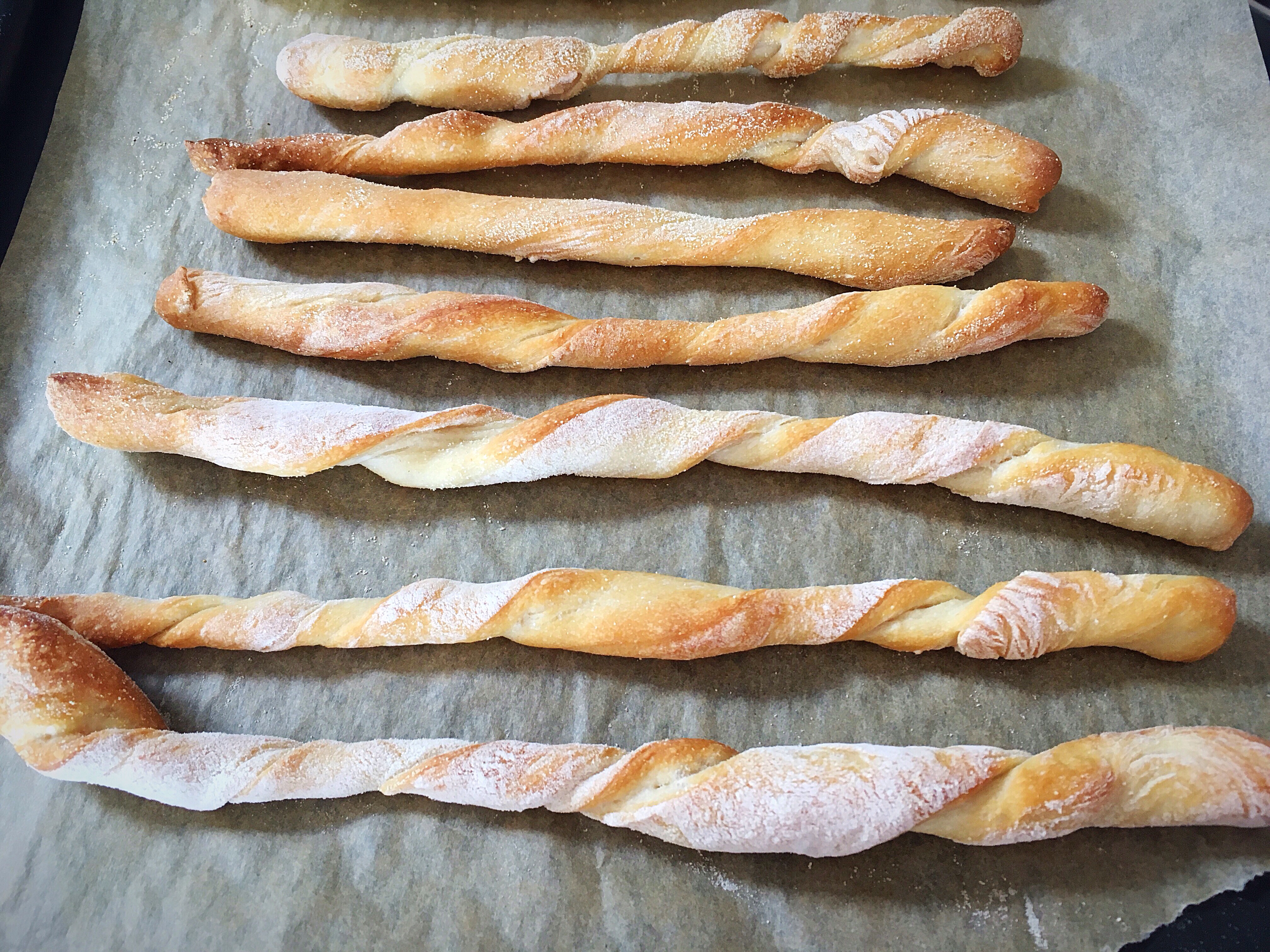 A bunch of bread sticks are laying on the table