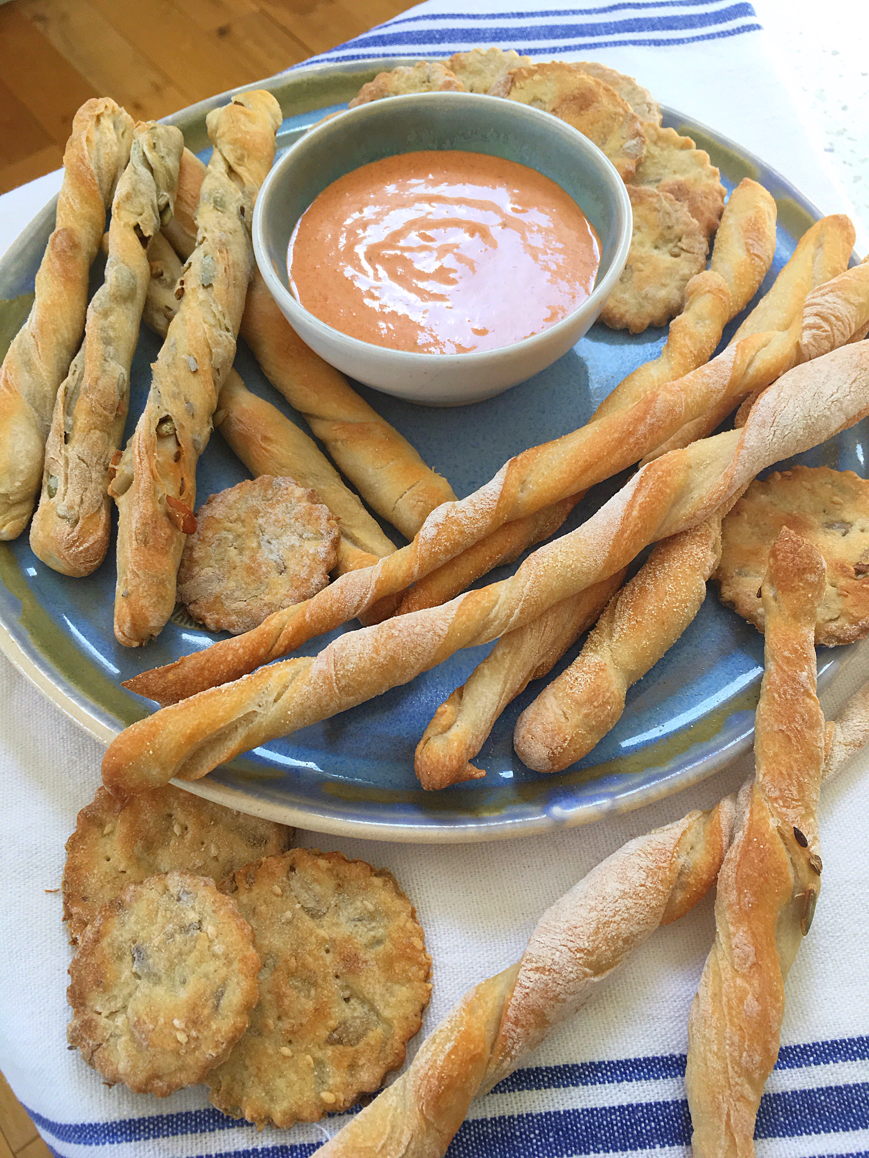 A plate of bread sticks and dipping sauce.