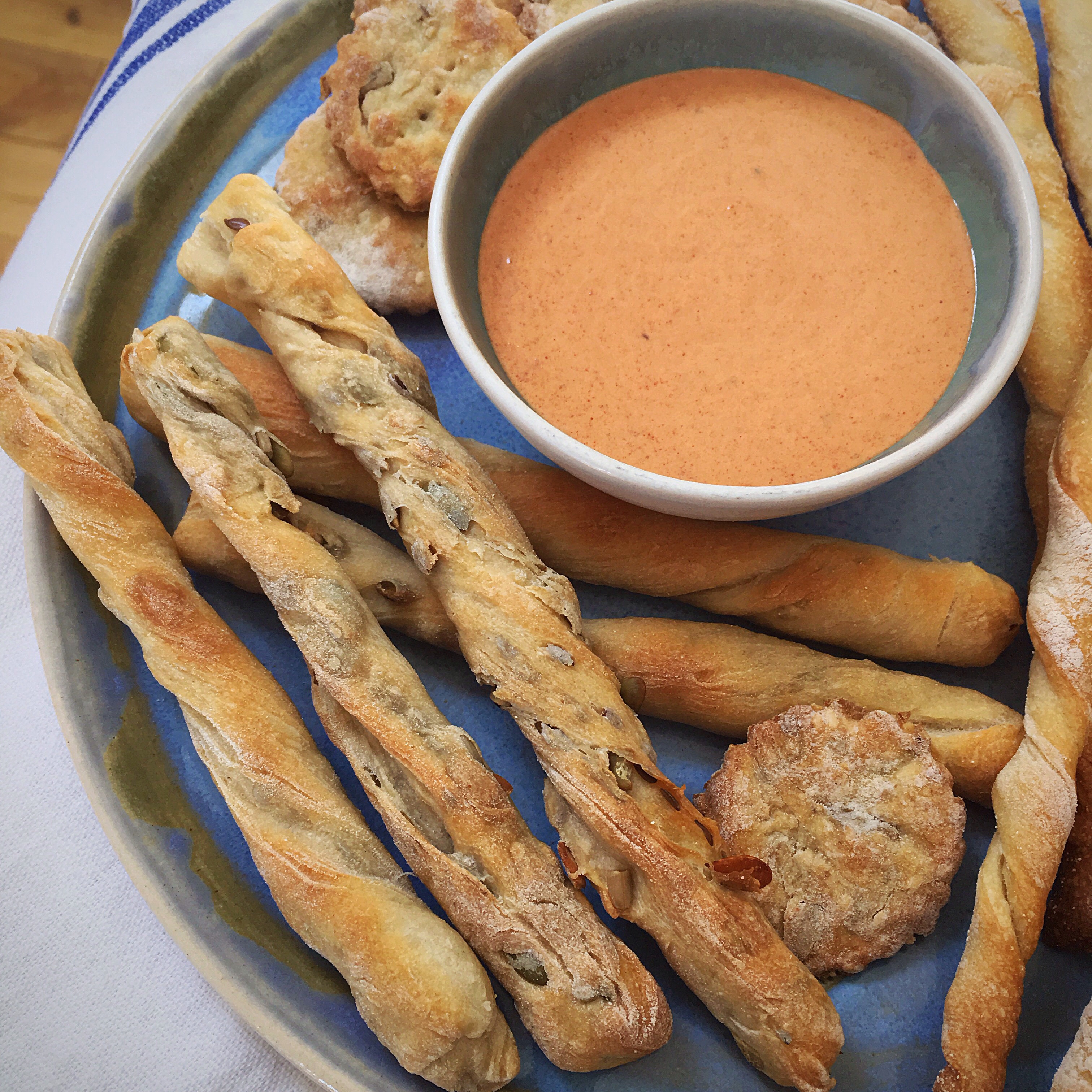 A plate of bread sticks and dipping sauce.