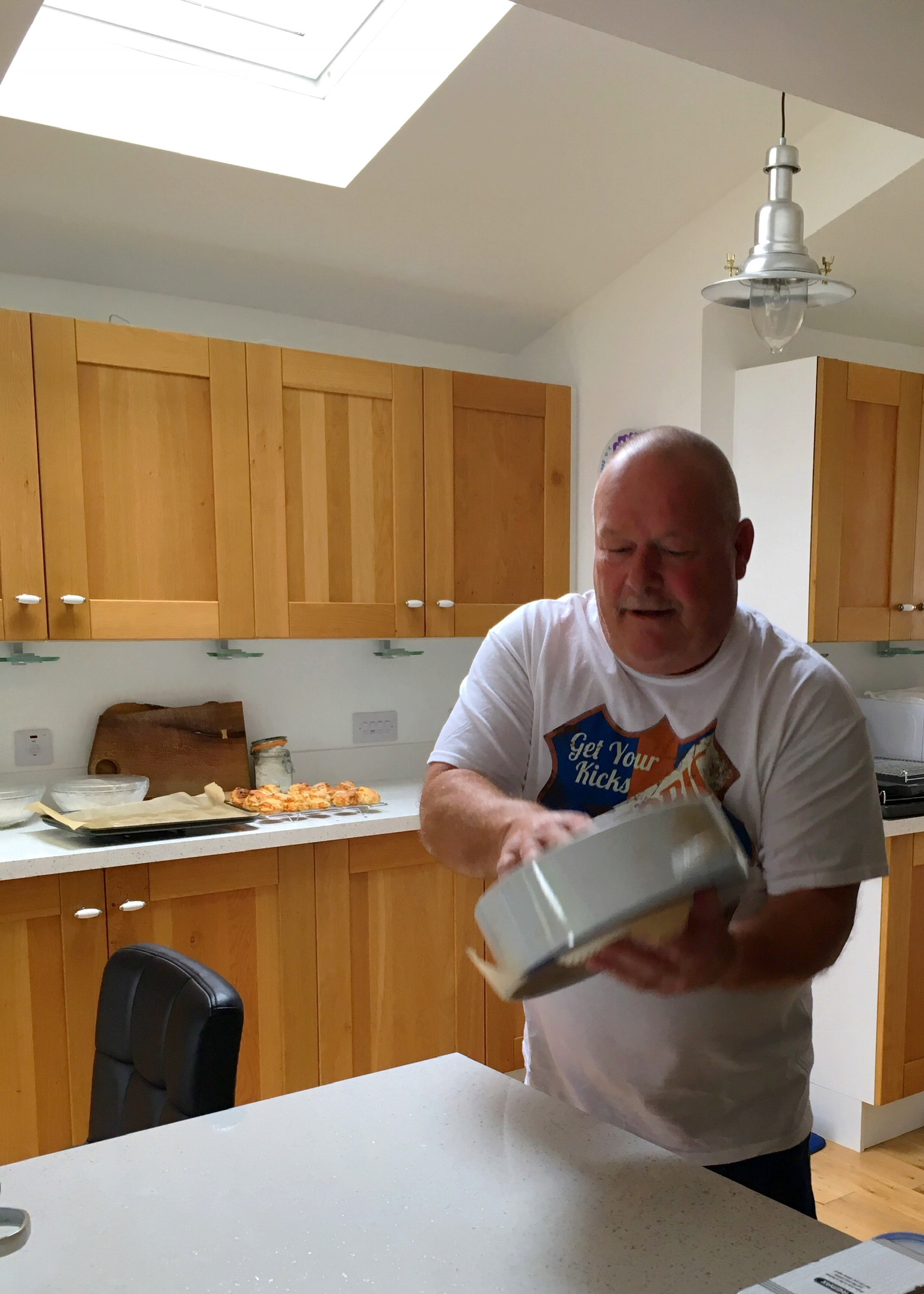 A man in the kitchen holding something