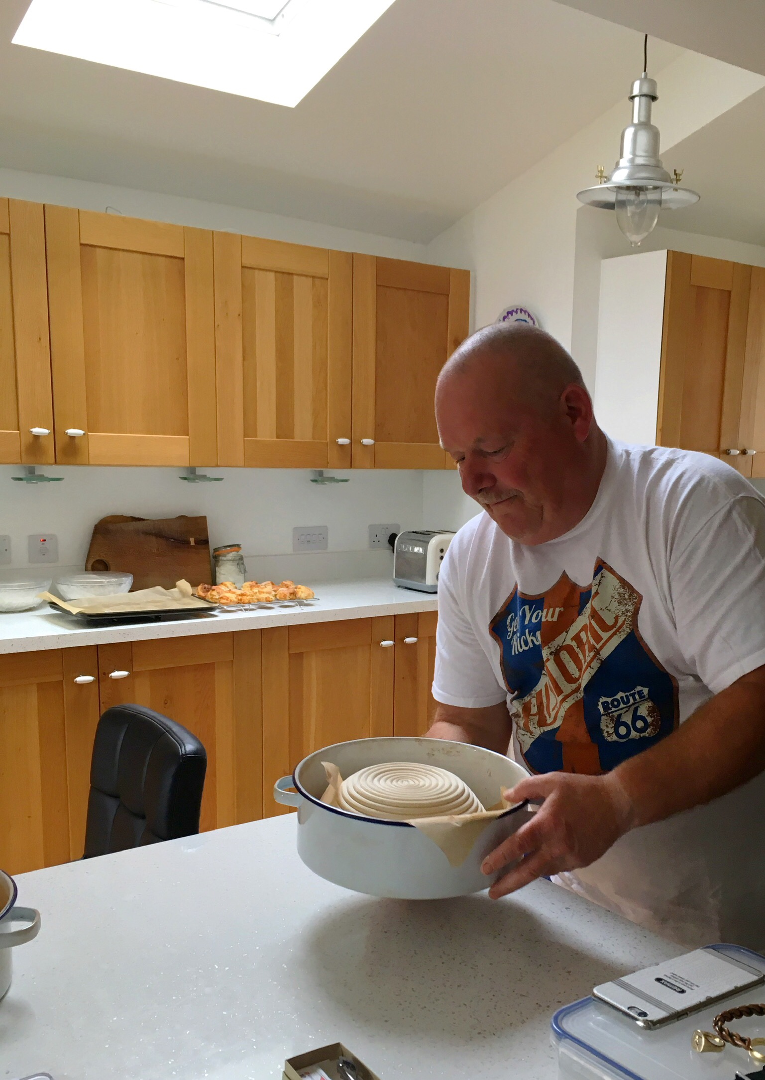 A man in white shirt holding bowl of food.