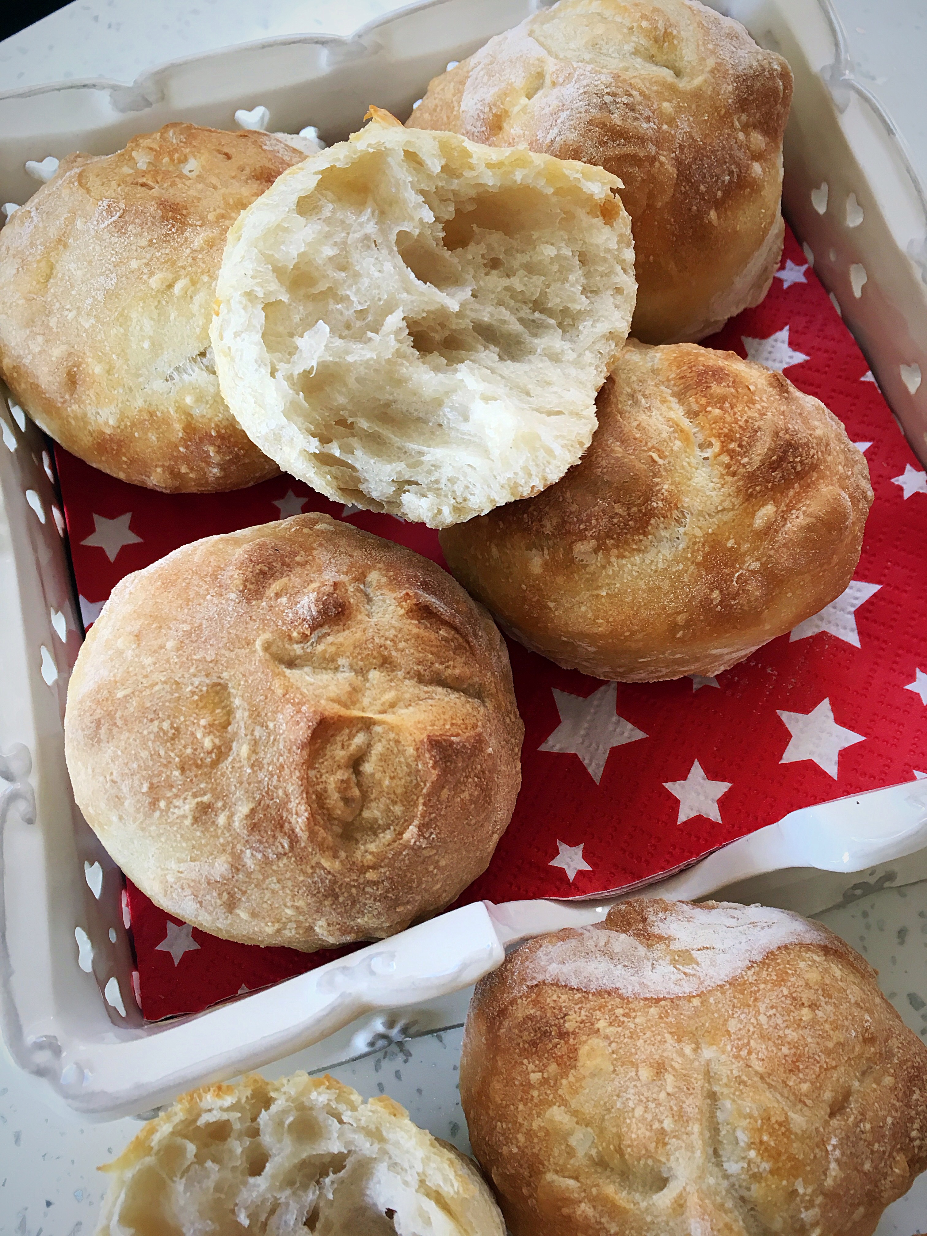 A basket of biscuits on top of a red and white star paper.