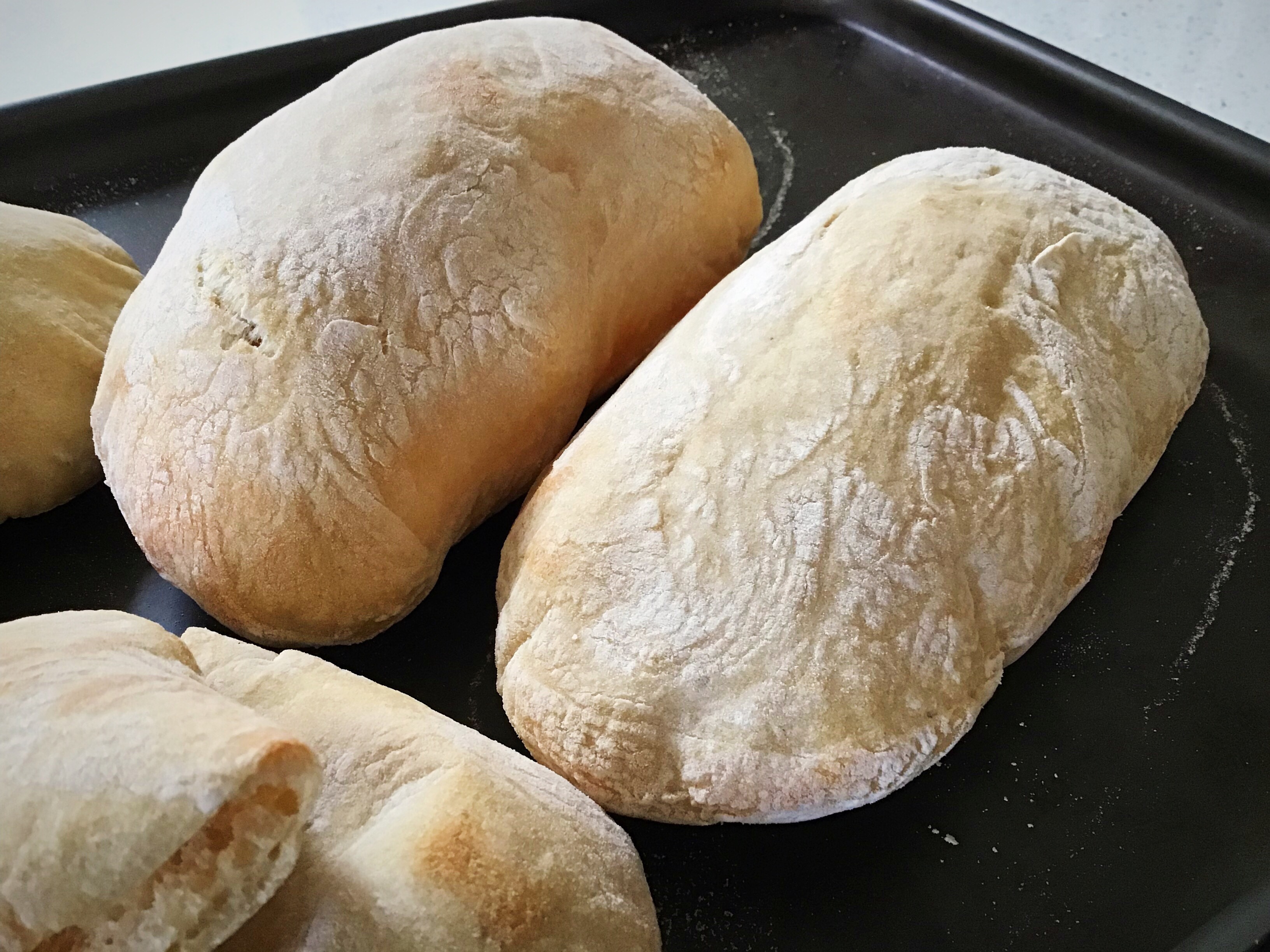 Two loaves of bread sitting on a pan.