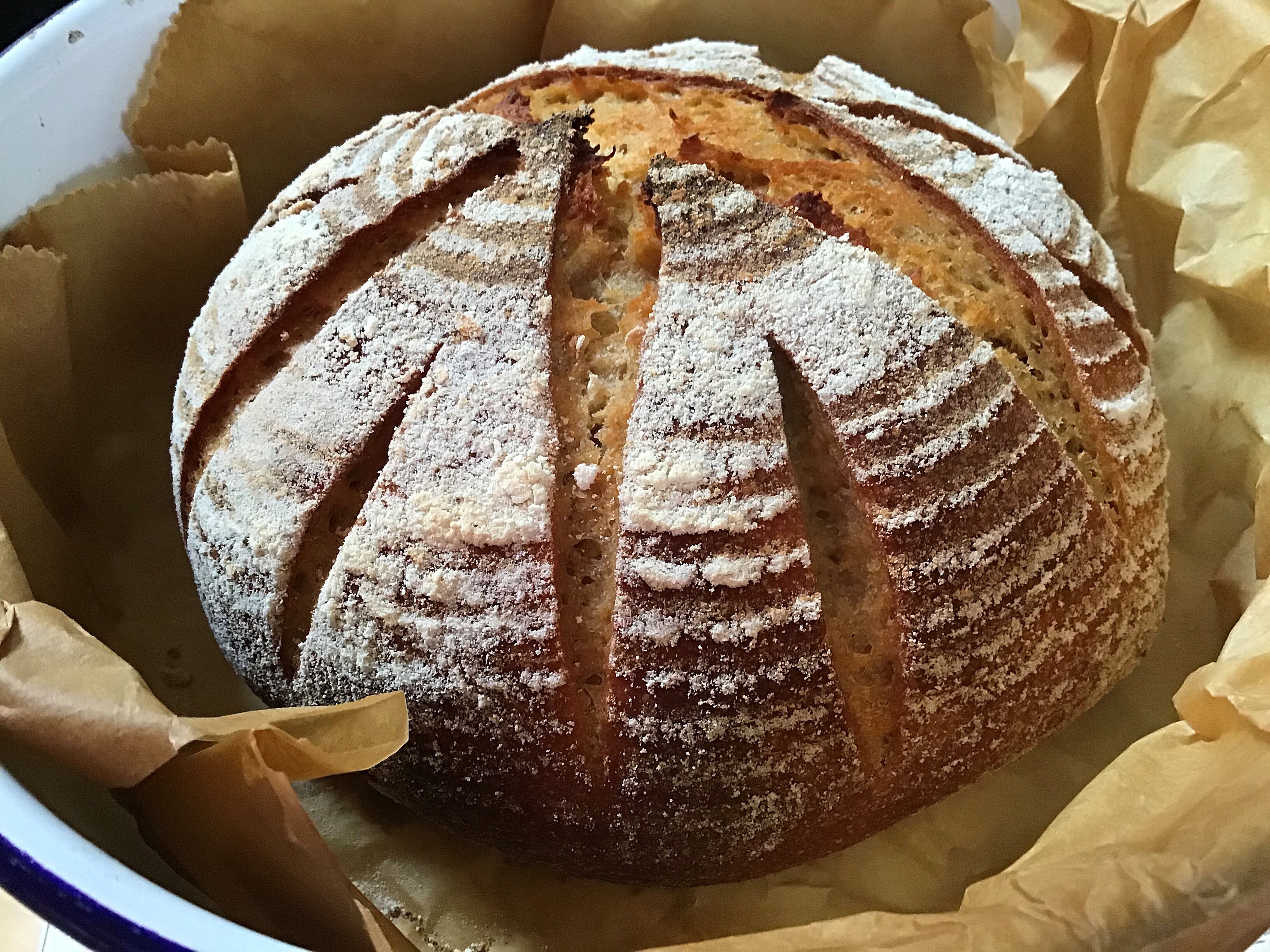 A loaf of bread in a basket with some type of crust.