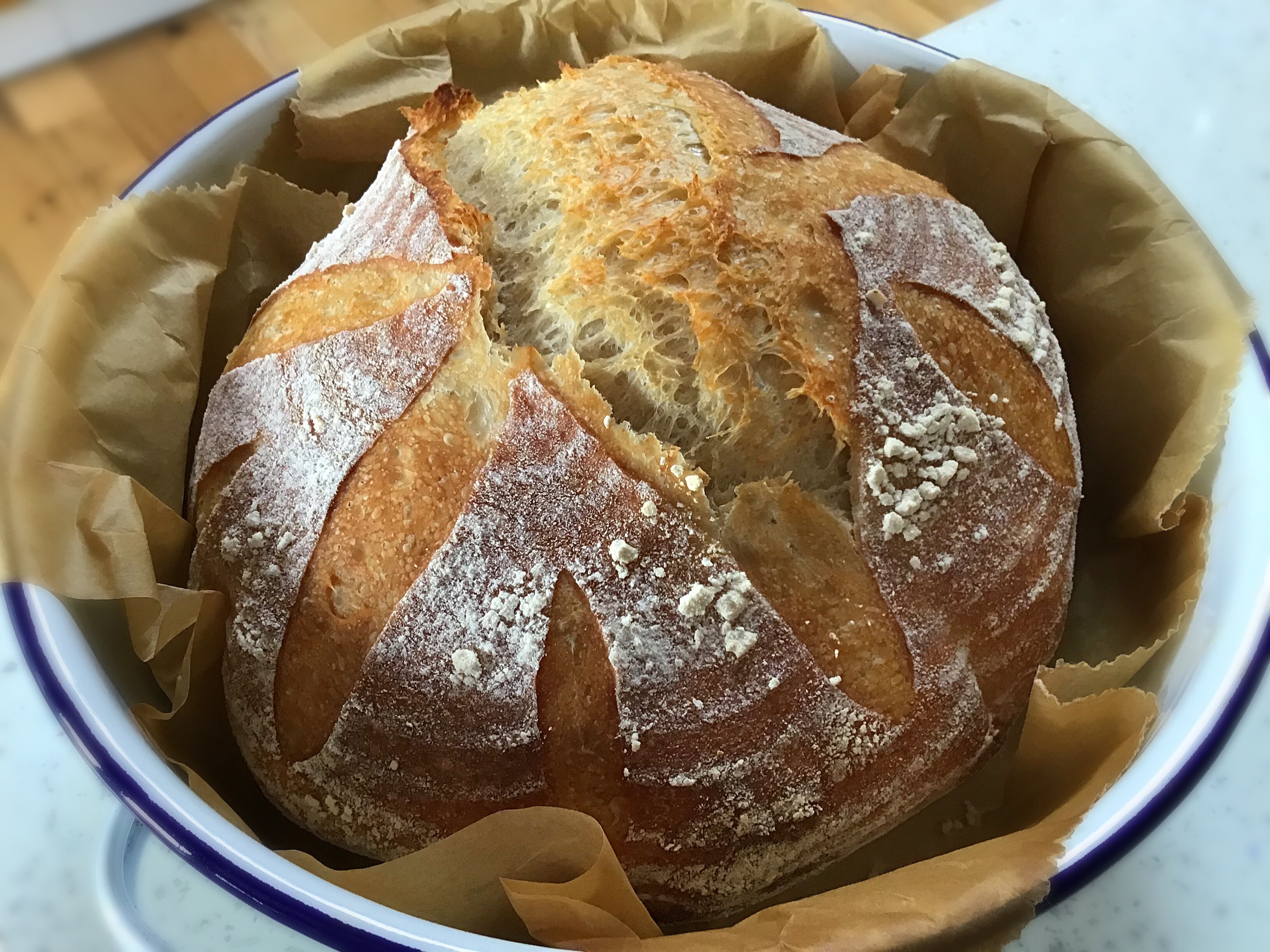 A loaf of bread in a bowl on top of a table.