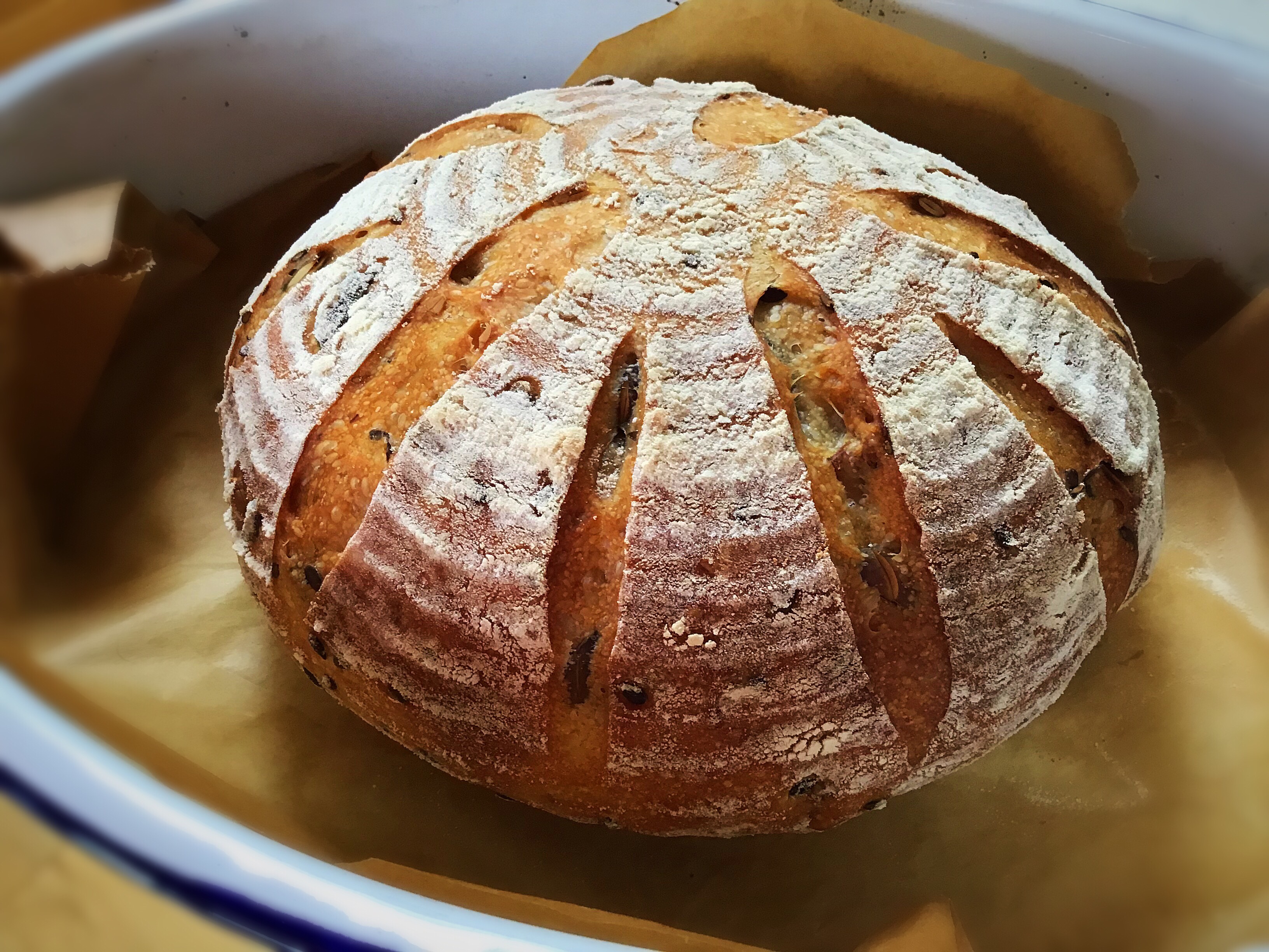 A loaf of bread in a bowl on wax paper.