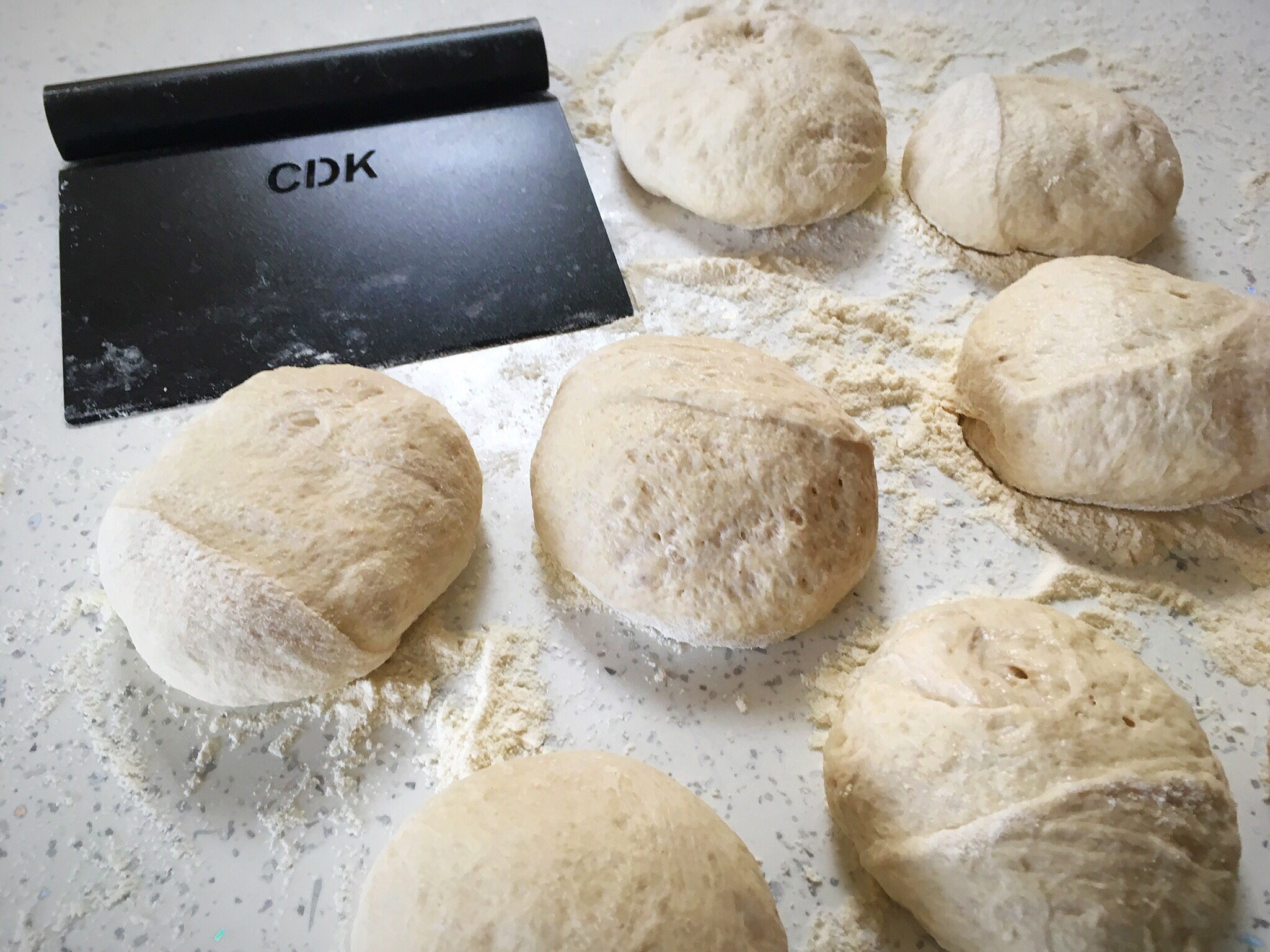 A table with some dough balls and a tablet