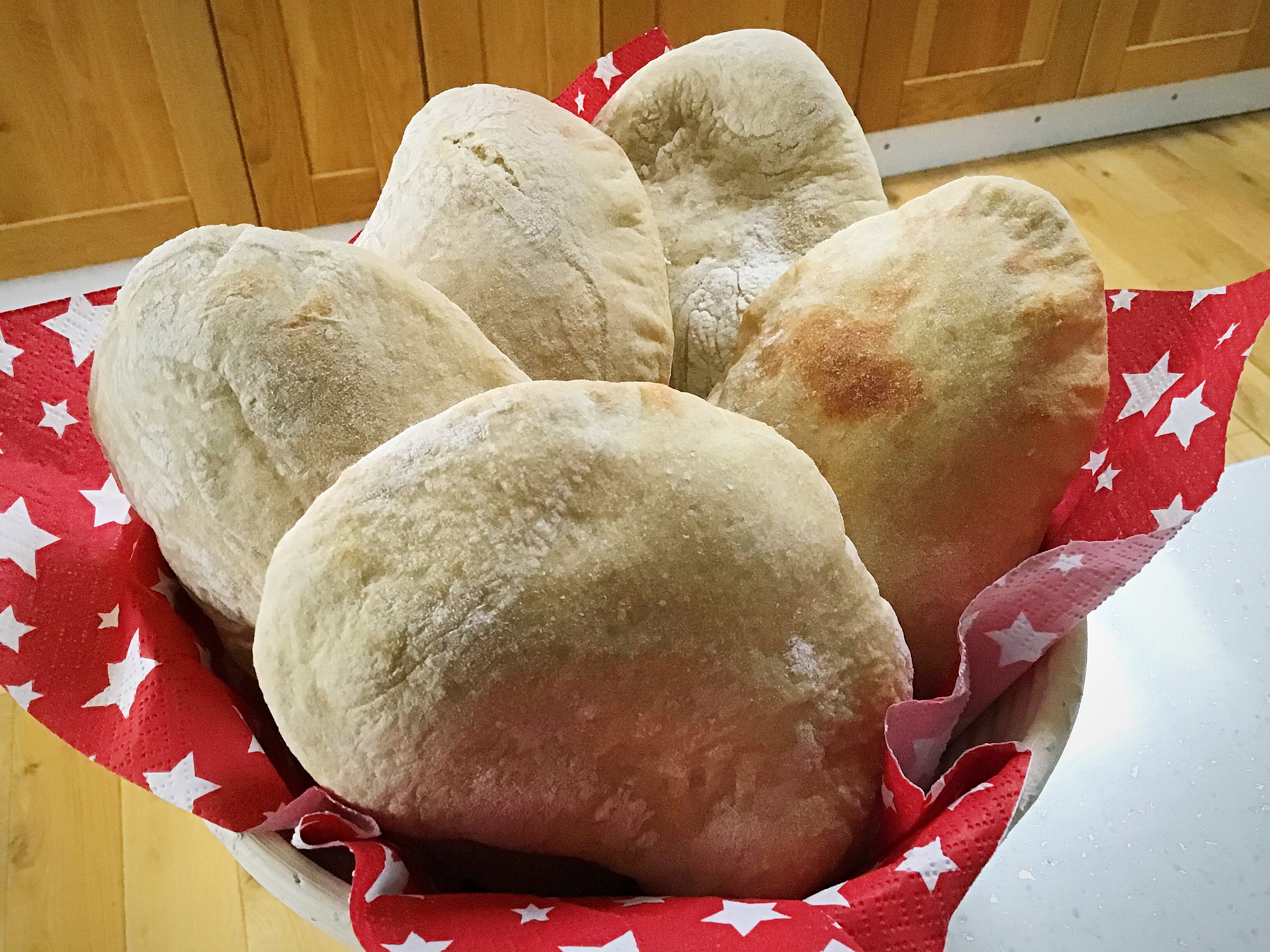 A basket of bread rolls sitting on top of the floor.