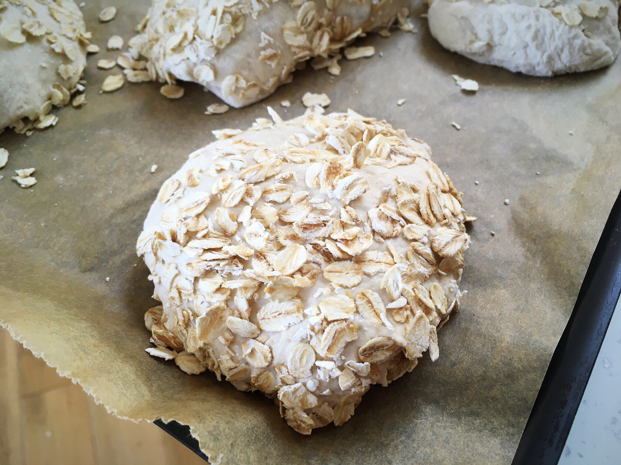 A round cake covered in white frosting and nuts.