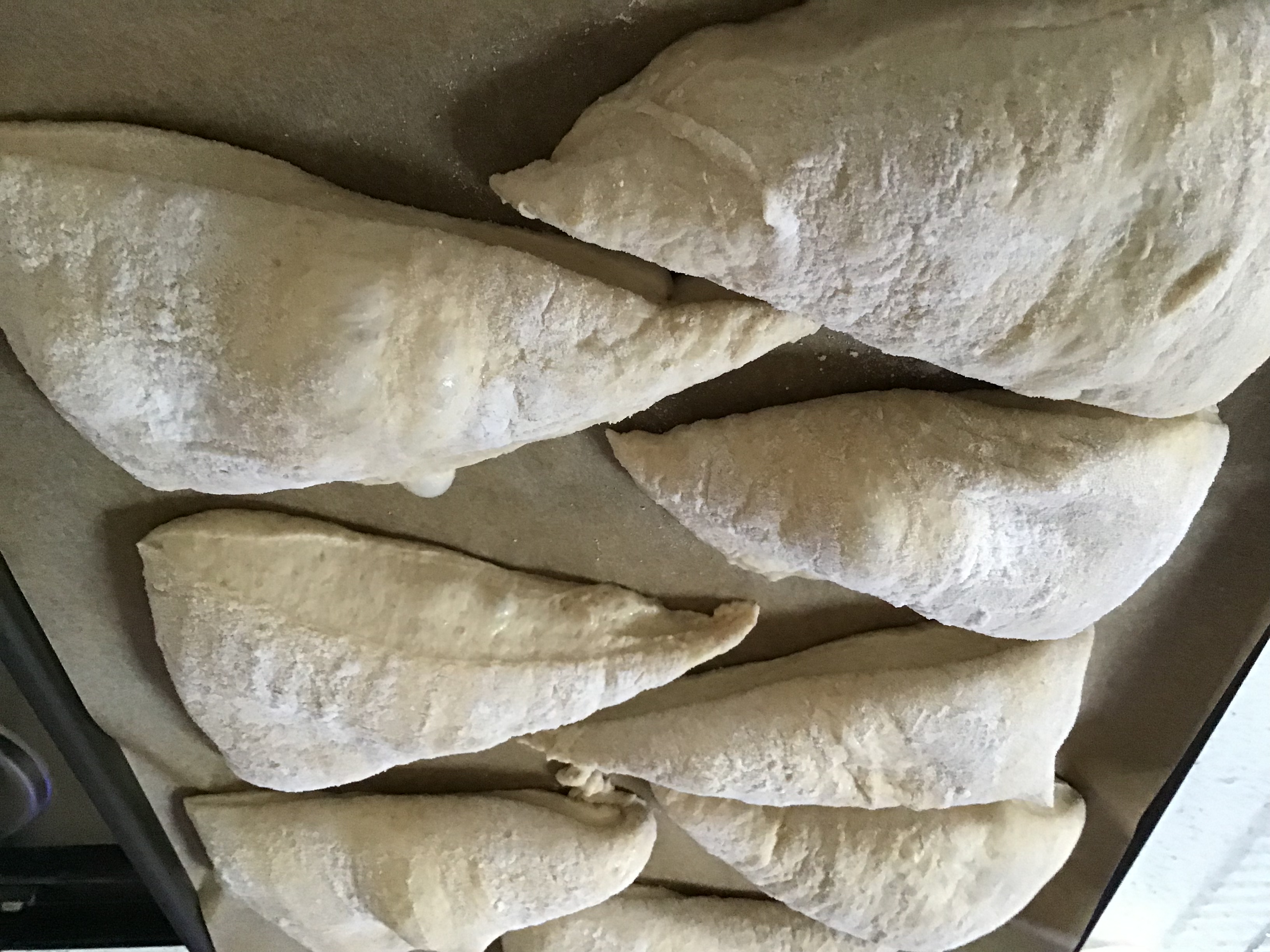 A tray of uncooked pastries on top of brown paper.