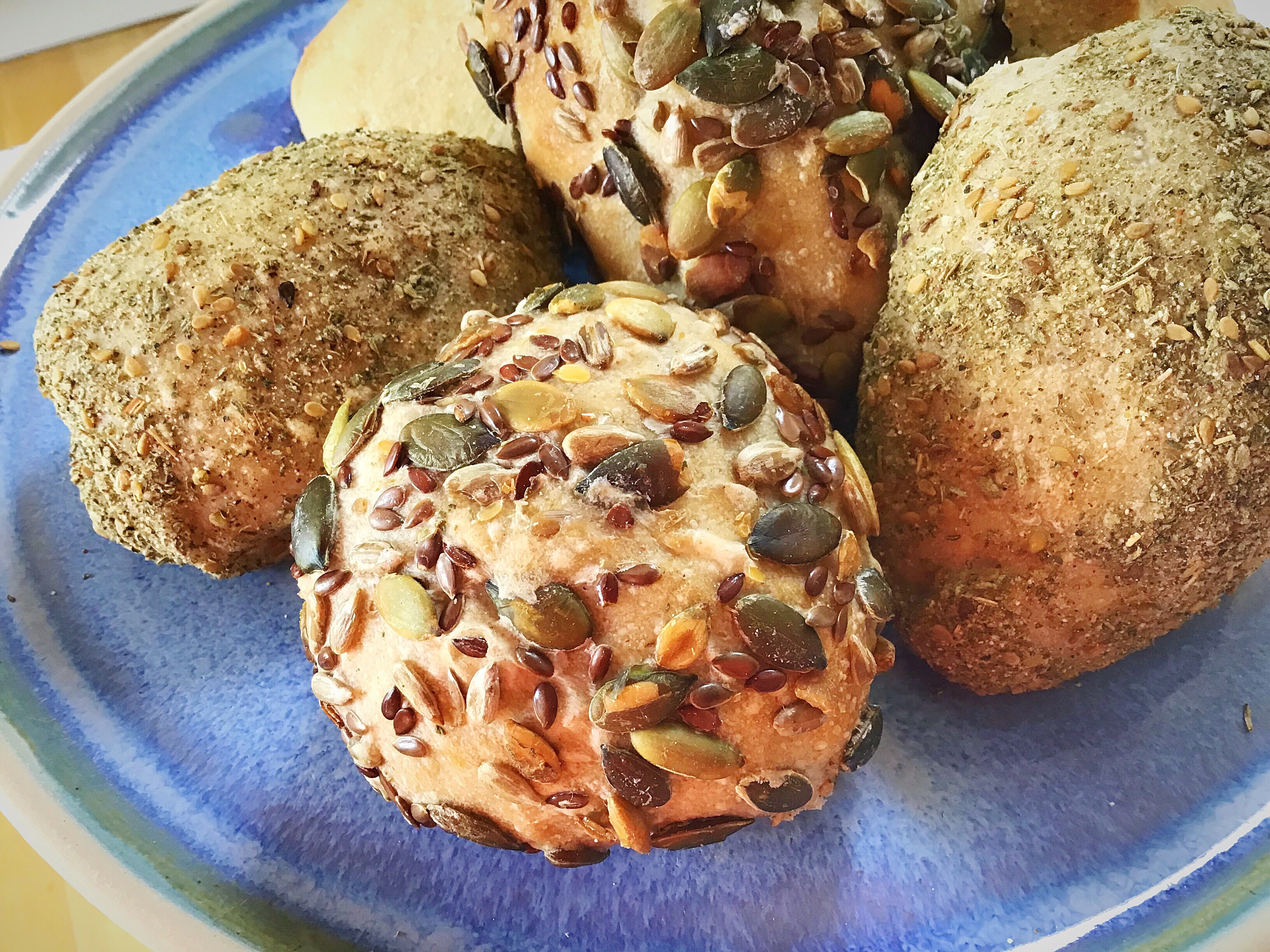 A blue plate topped with cookies covered in nuts.