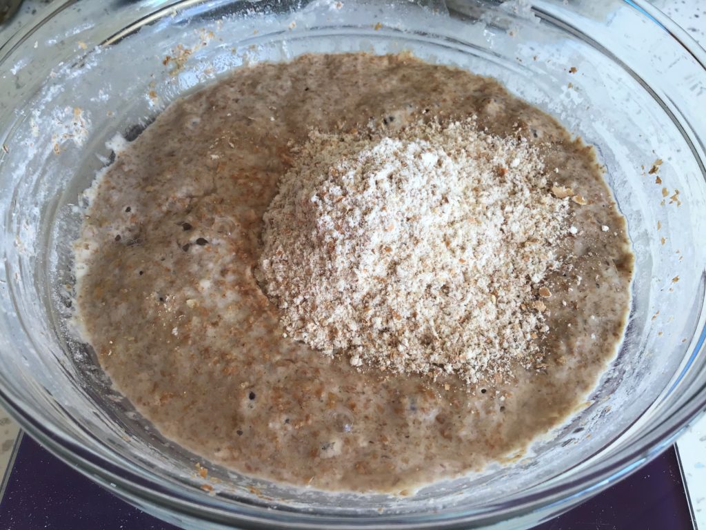 A bowl of oatmeal with some type of brown substance.