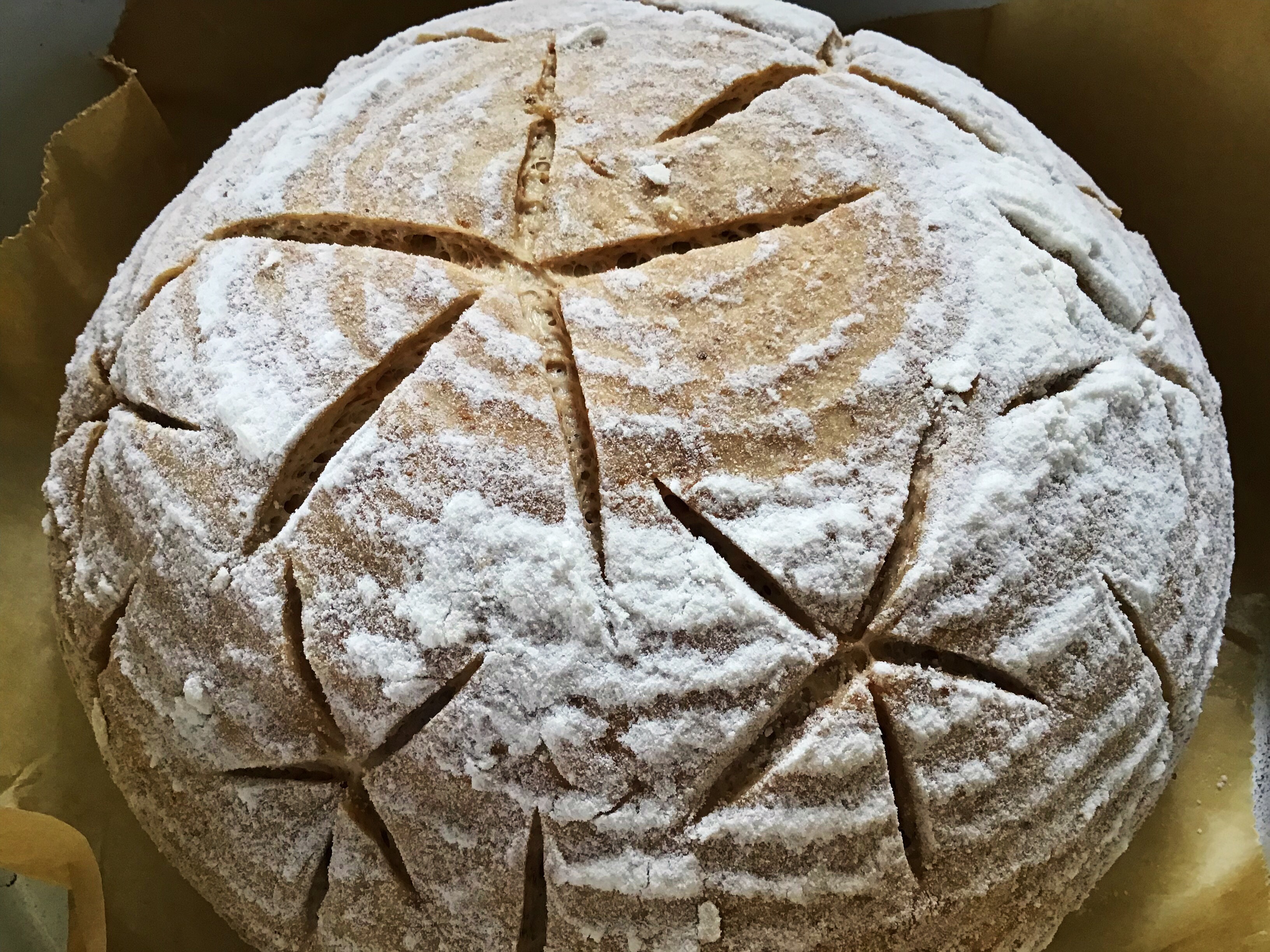 A loaf of bread with some white flour on it