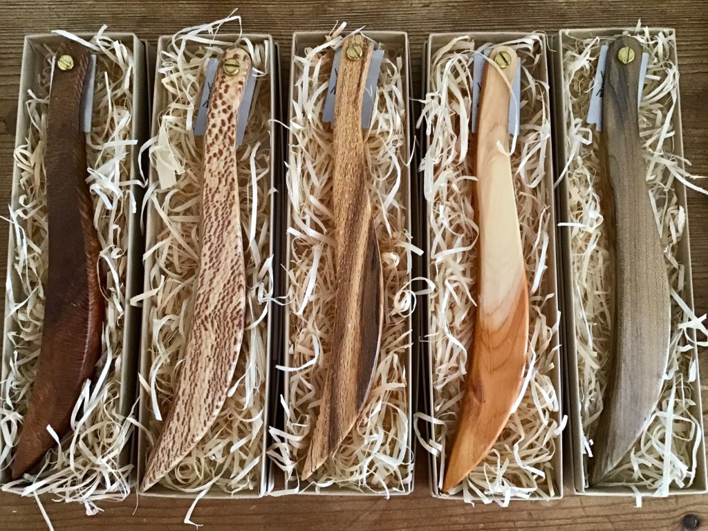 A set of five wooden knives in boxes.