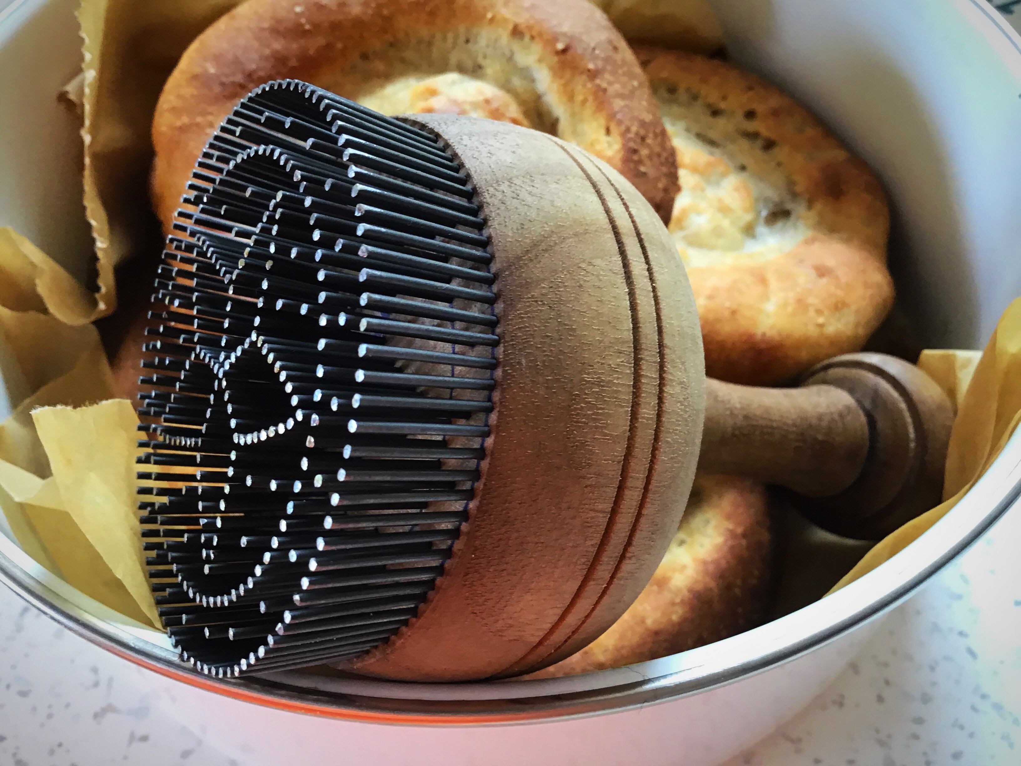 A bowl of bread with a wooden handle.