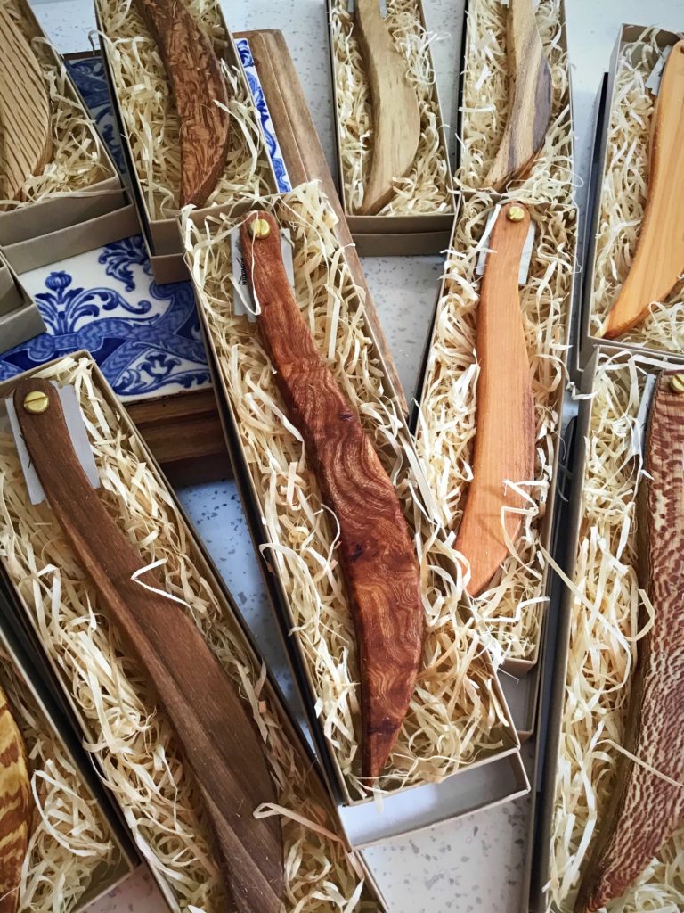 A bunch of knives in boxes on top of each other