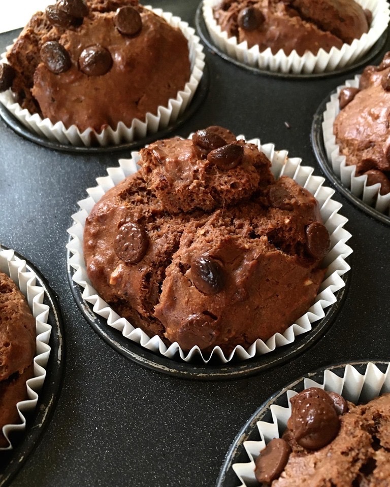 A close up of some chocolate muffins in paper wrappers