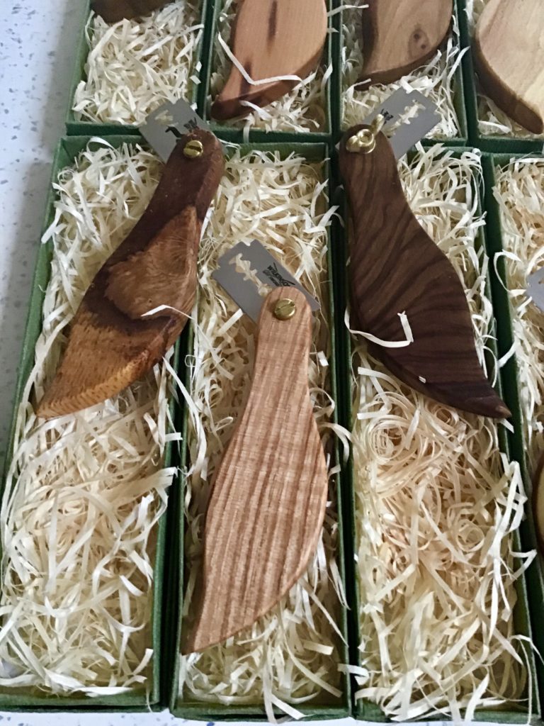 A box of wooden knives in the grass.