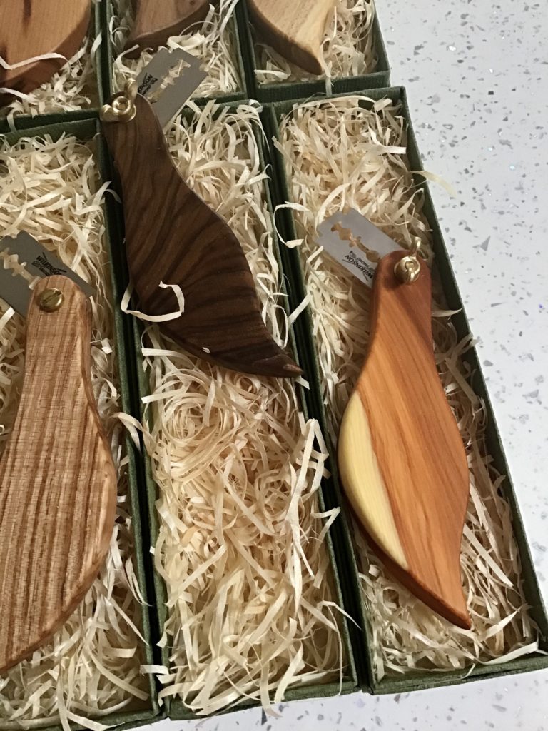 A wooden knife set in a box with some wood shavings