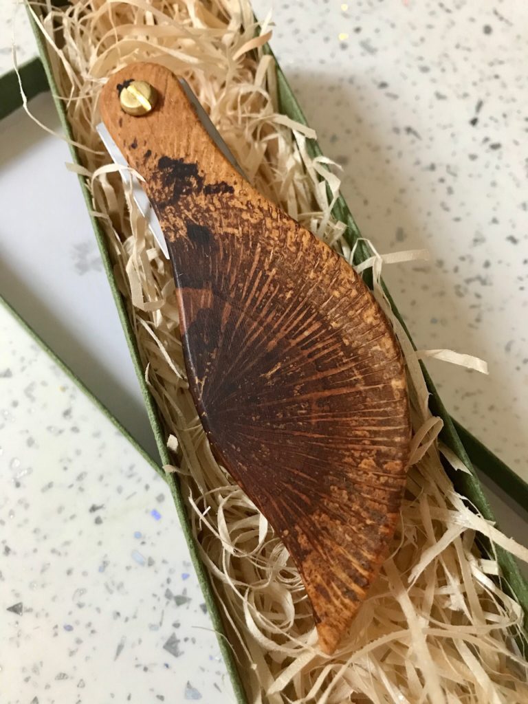 A wooden knife with a carved bird on it.