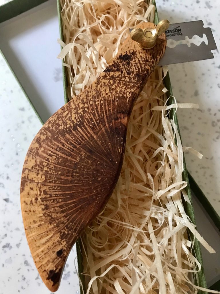 A brown slug sitting on top of some shredded paper.