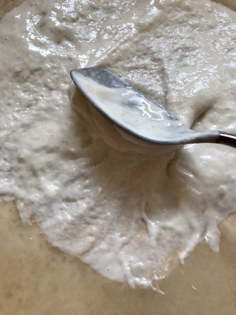 A spoon is on top of some flour.