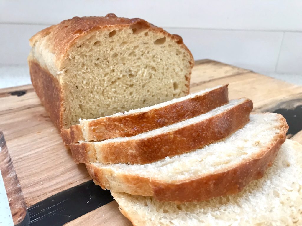 A loaf of bread on top of a wooden board.