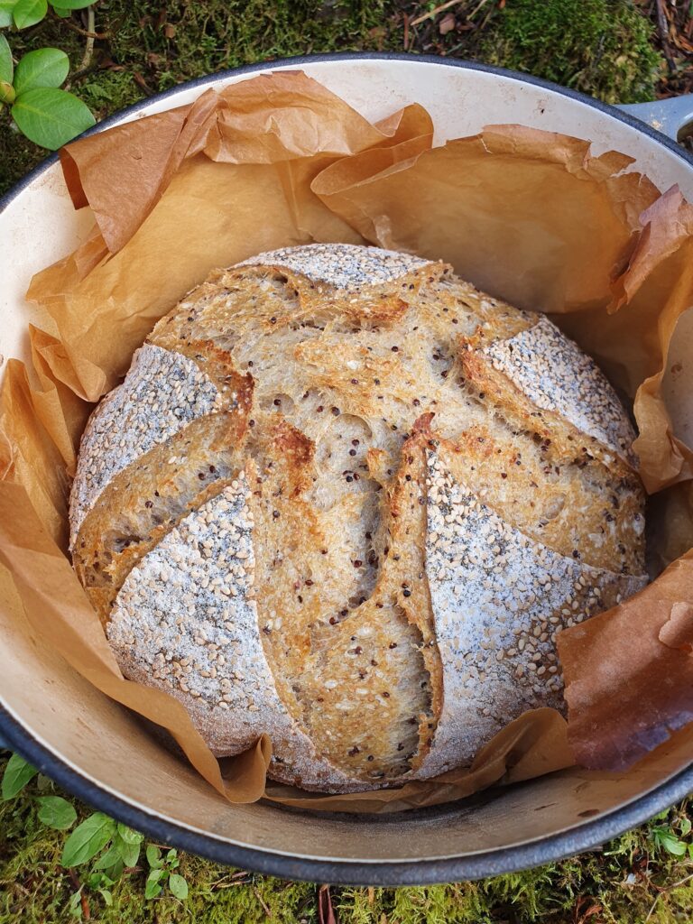 A loaf of bread in a bowl with some brown paper.