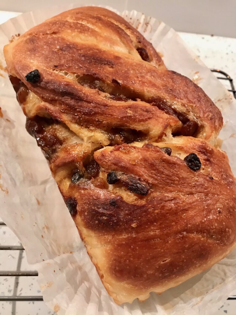 A loaf of bread with raisins on top.