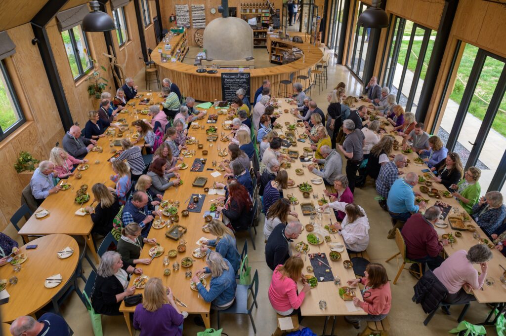 A large group of people sitting at tables eating.